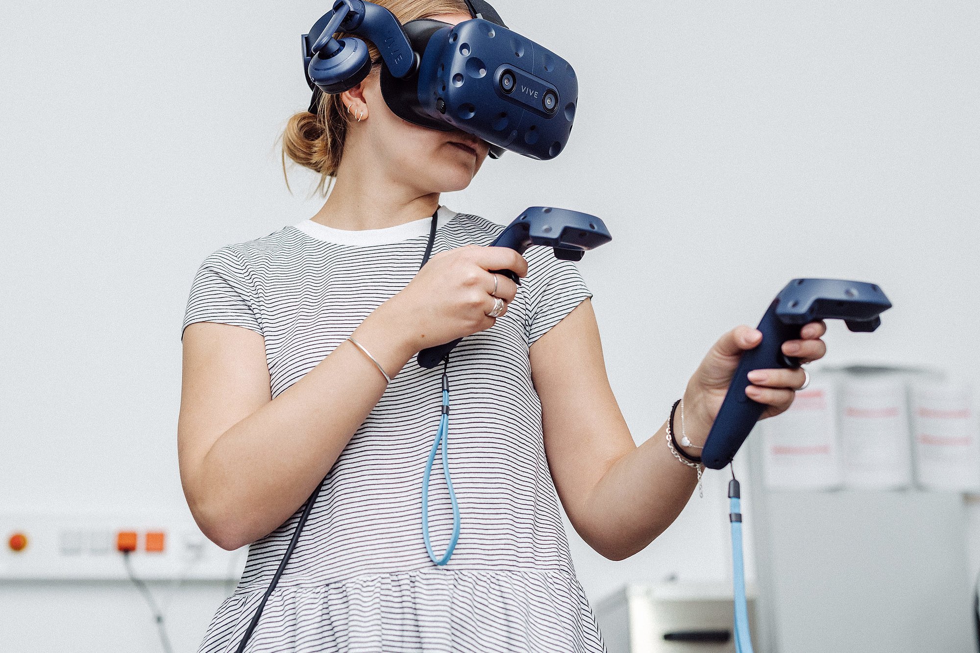 Person trägt VR-Brille und Joysticks in beiden Händen