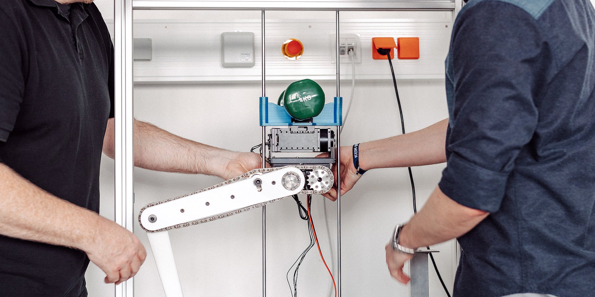 Zwei Personen arbeiten an einem technischen Gerät.