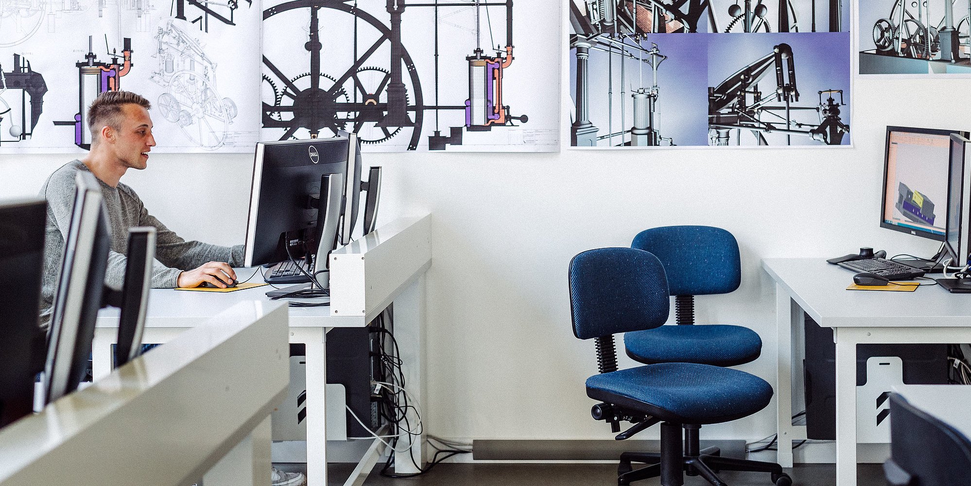 Eine Person sitzt in einem Büro und arbeitet am Computer.