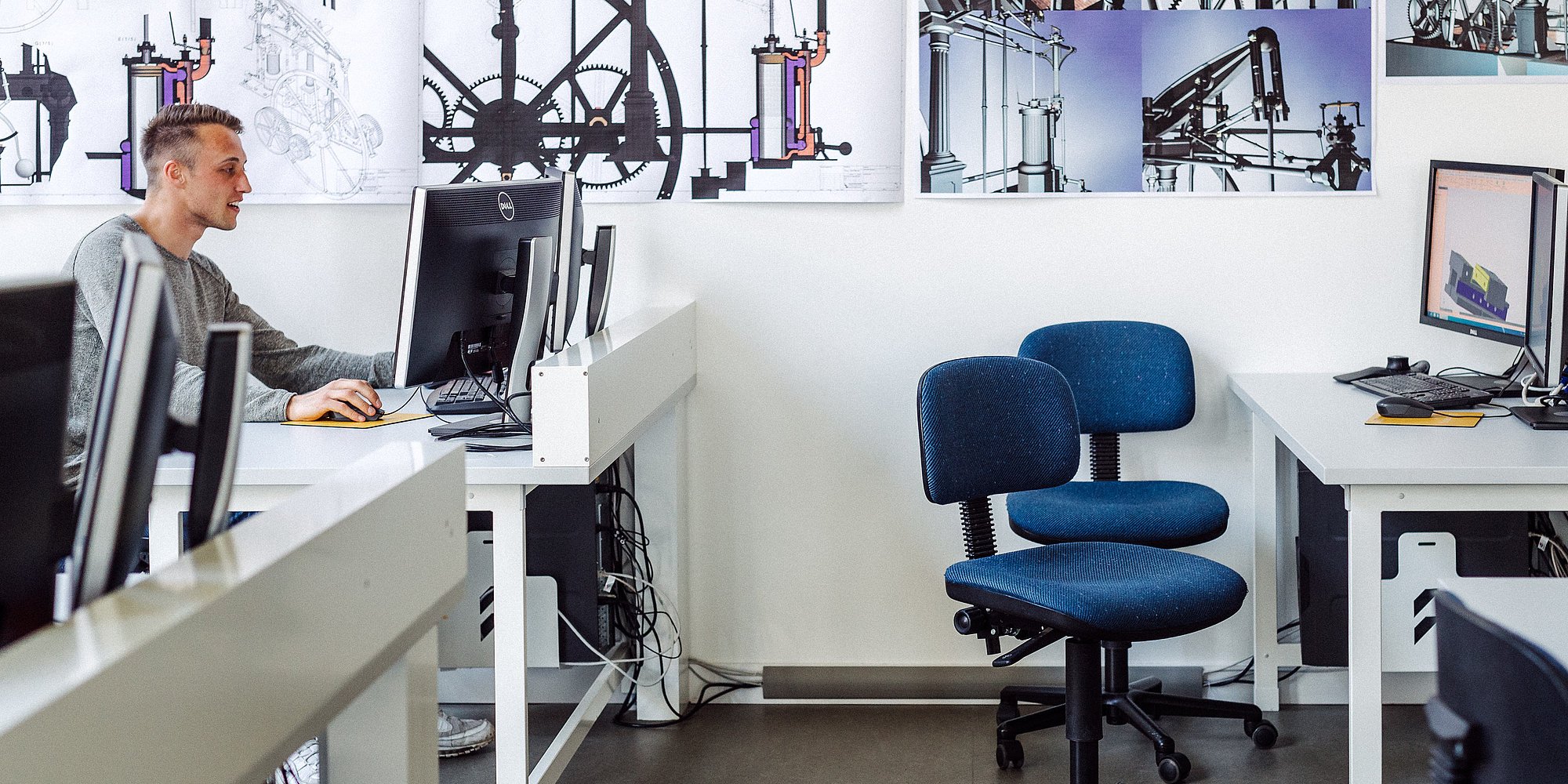 Eine Person sitzt in einem Büro und arbeitet am Computer.