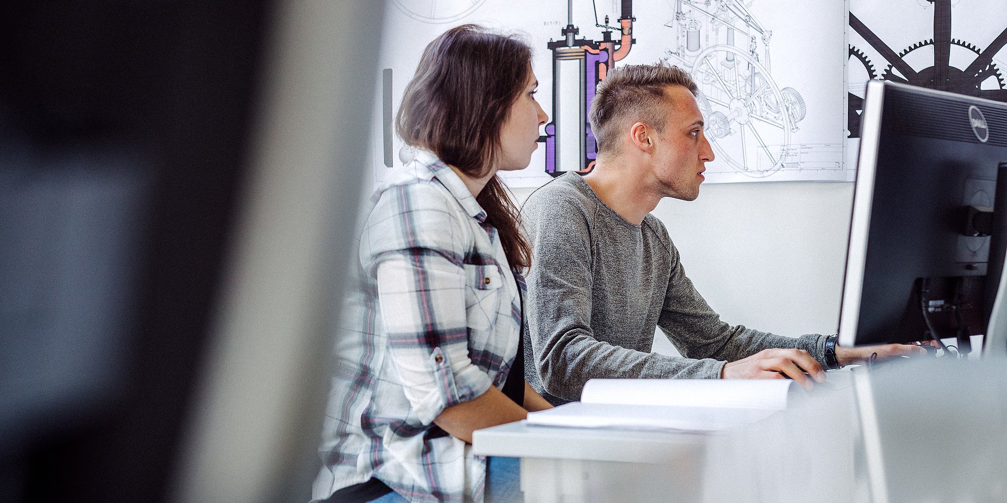 Zwei Personen arbeiten gemeinsam an einem Computer